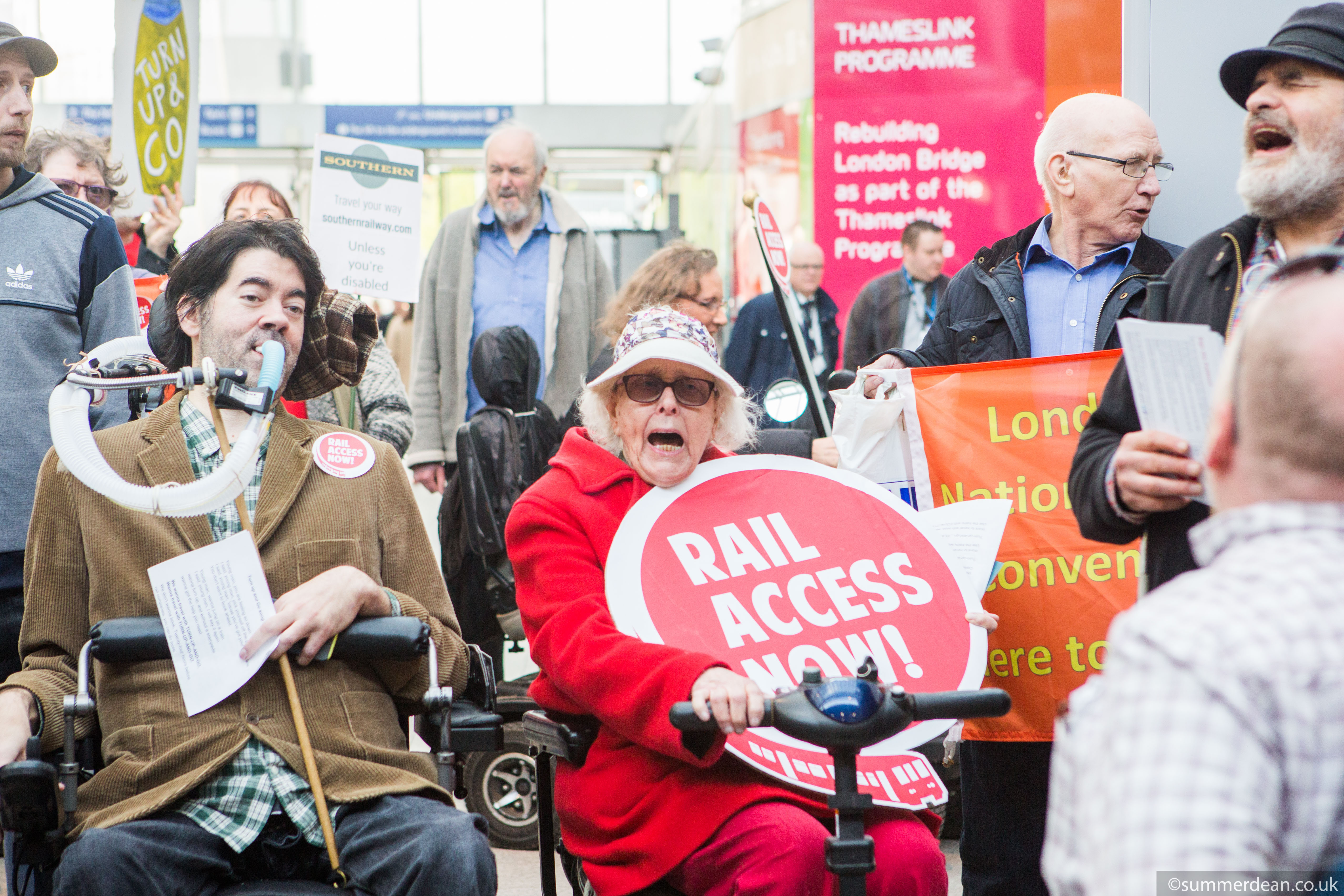 Disabled campaigners protest at London Bridge station. Their placards read: "Rail Access Now!"